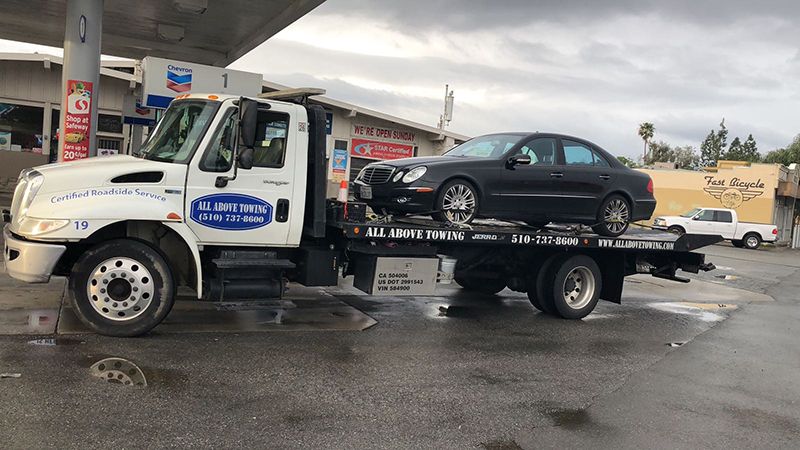 Image of Towing truch with a black car,ALL Above Towing LLC,Tow Truck Company 